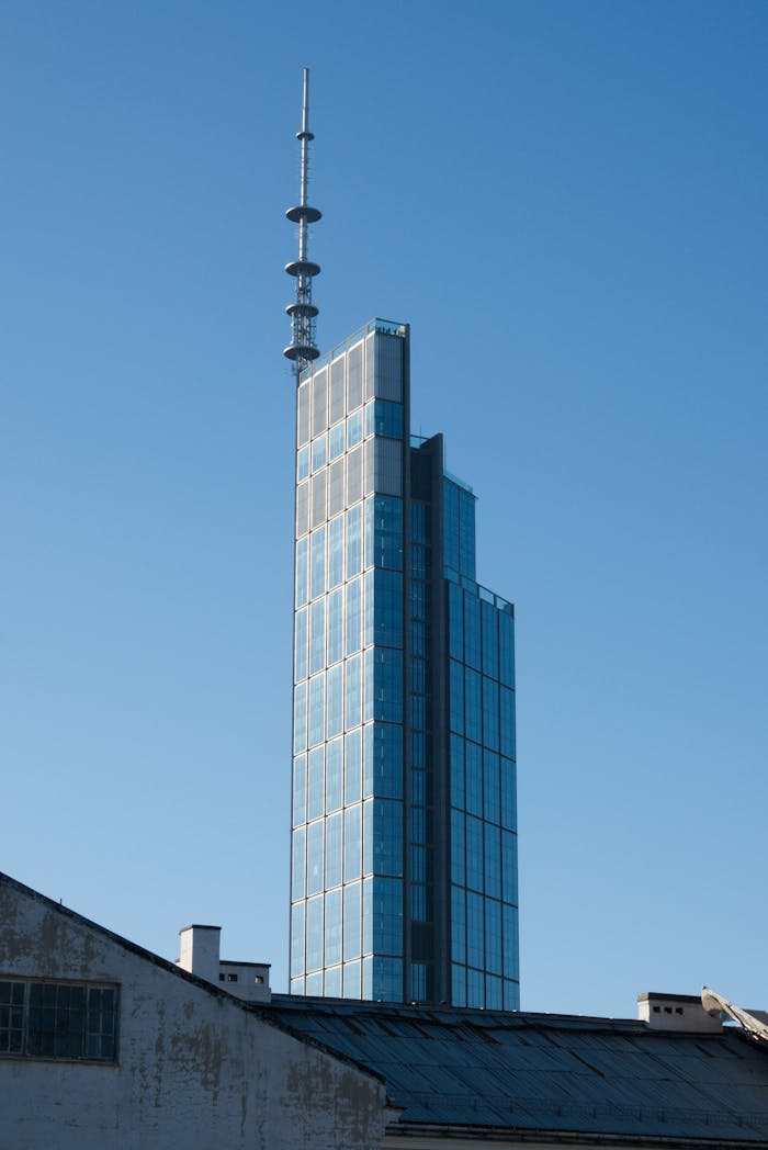 Contemporary skyscraper against a clear blue sky in Warsaw, Poland, showcasing architectural design.