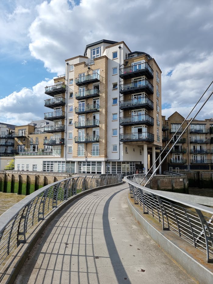 Modern apartment building along a curved river pathway in London, England.