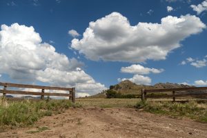 valley landscape with an open wooden fence under the cloudy sky